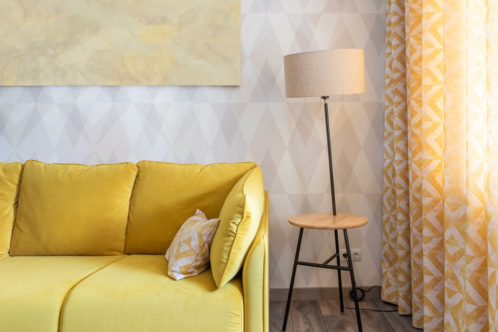 Żółta sofa i lampa podłogowa